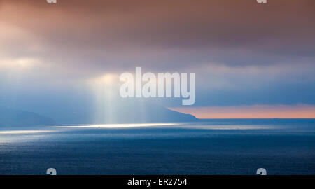 Volumen-Sonnenlicht geht durch dunkle Wolken. Bucht von Tanger, Marokko, Afrika Stockfoto