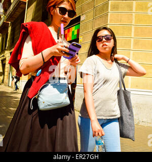 Zwei junge Frauen mit Sonnenbrillen auf der Straße. Stockfoto