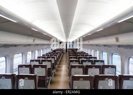 Interieur der japanischen shinkansen, Hochgeschwindigkeitszug, Serie 700, Standard-Klasse Eisenbahnwagen während der Reise. Wagen ist fast emty. End-to-End-Ansicht. Stockfoto