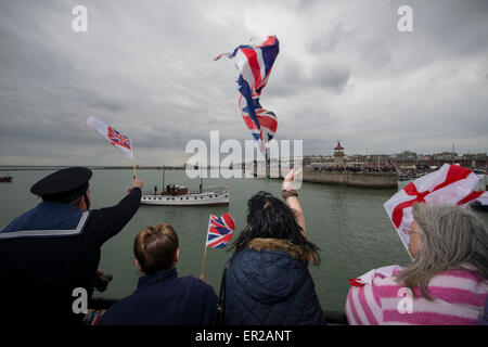 Zuschauer Welle Fahnen und jubeln, wie sie die zurückkehrenden Dünkirchen kleine Schiffe zurück in den Hafen von Ramsgate begrüßen. Die Schiffe sind nach dem Segeln in Dünkirchen nach des 75. Jahrestages der Operation Dynamo zurückgekehrt. Stockfoto