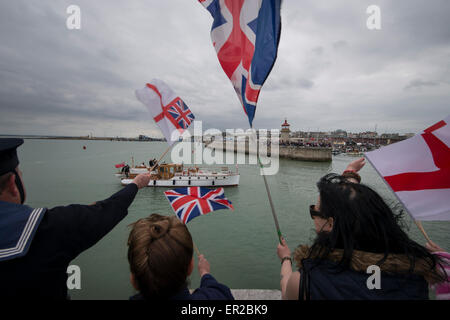 Zuschauer Welle Fahnen und jubeln, wie sie die zurückkehrenden Dünkirchen kleine Schiffe zurück in den Hafen von Ramsgate begrüßen. Die Schiffe sind nach dem Segeln in Dünkirchen nach des 75. Jahrestages der Operation Dynamo zurückgekehrt. Stockfoto