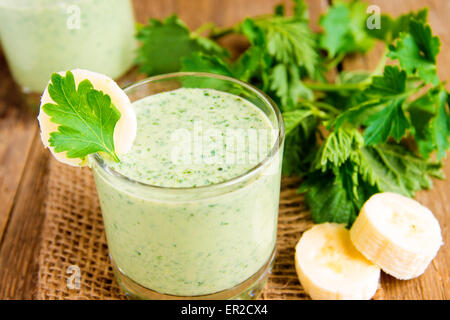 Kalten Smoothie aus Banane, Yougurt, Kräuter und Gemüse auf Holztisch, Nahaufnahme horizontal Stockfoto