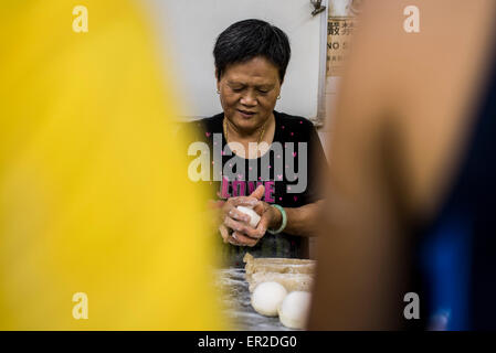 Cheung Chau Insel. 25. Mai 2015. Eine Frau kocht traditionelle Brötchen Kuchen in einer chinesischen Bäckerei vor der Piu Sik Parade beim Bun Festival in Cheung Chau Insel am 25. Mai 2015 in Hong Kong. Eines Hong Kongs buntesten Kulturfest Ereignisse, Cheung Chau Bun Festival findet statt am 25. Mai 2015 bis 26. Mai 2015 Mitternacht. Jedes Jahr steigen Tausende von Menschen auf die winzige Insel für The Piu Sik Parade, Lucky Brötchen und The Bun kriechen, Wettbewerb, der alte Brauch während des Festivals. Die Tradition wurde seit Generationen weitergegeben. Bildnachweis: Xaume Olleros/Alamy Live-Nachrichten Stockfoto