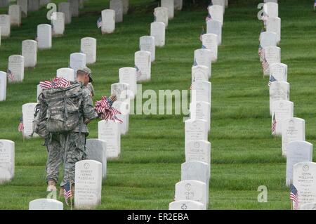 Ein Soldat der US Army aus der alten Garde legt Flaggen vor Grabstätten zu Ehren des Memorial Day auf dem Arlington National Cemetery 21. Mai 2015 in Arlington, Virginia. Die alte Garde dirigierte Flaggen-in, wenn eine amerikanische Flagge befindet sich bei jedem Grabstein seit 1948. Stockfoto