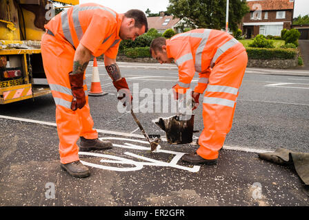 Zwei Männer markieren einen Radweg mit heißen thermoplastischen Paint. Stockfoto