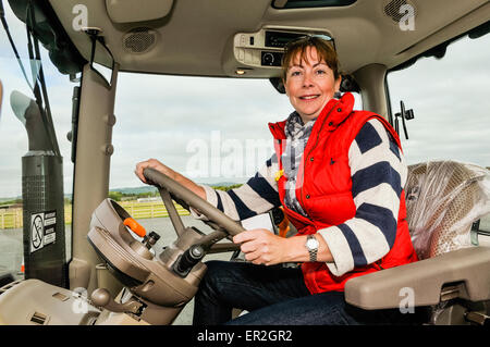 Eine Frau fährt einen Traktor von John Deere 6125R Stockfoto