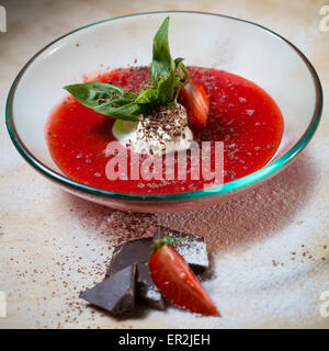 Erdbeer-Suppe mit Eis und Minze auf einem Teller Decoratedfresh Erdbeeren Stockfoto