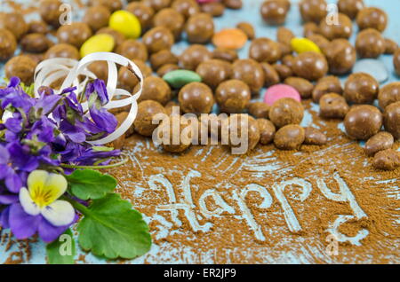 Schokokugeln auf einem Tisch mit dem Wort Happy Stockfoto