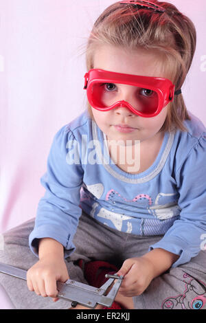 Kleines Mädchen Maßnahmen durch einen Bremssattel Durchmesser eines Bohrers. Stockfoto