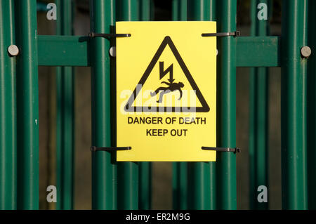 Gefahr von Tod, heraus halten! Gelbe Warnblinkleuchten Zeichen für die Sicherheit Zaun ein Strom sub Station verbunden. England, Vereinigtes Königreich. Stockfoto