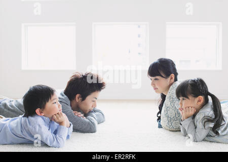 Junge Familie, die auf dem Boden Stockfoto