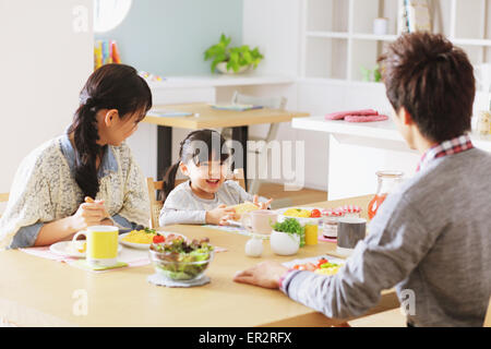 Jungen Erwachsenen paar und ihre Tochter in ihrem Speisesaal frühstücken Stockfoto