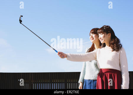 Zwei junge japanische Frauen, die eine Selfie mit Selfie stick Stockfoto