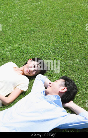 Japanische Brautpaar Verlegung auf Rasen in einem park Stockfoto
