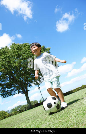 Japanische Jungen spielen Fußball in einem Stadtpark Stockfoto