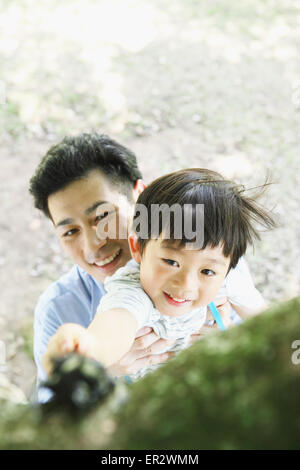 Glückliche japanischen Vater und Sohn fangen Insekten in einem Stadtpark Stockfoto