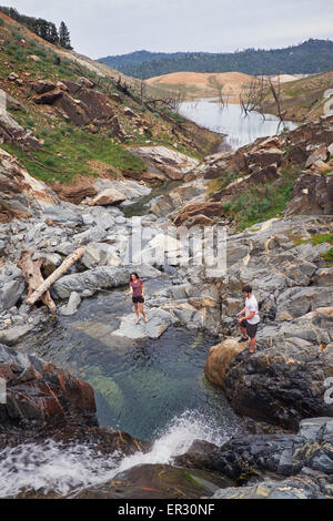 Ein junges Paar Fischen am Fuße eines Wasserfalls in einer kleinen Bucht im Norden Kaliforniens. Stockfoto