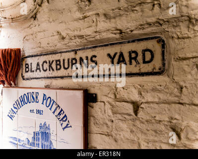 Schilder am Eingang nach Blackburn-Hof und die Waschküche Keramik unter der gewölbten Eingang von Kirche Straße Whitby Stockfoto