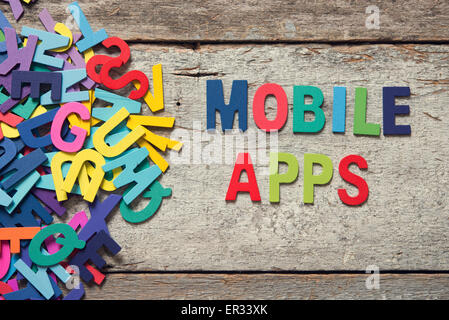 Die bunten Worte "MOBILE APPS" alten Holzbrett mit Holzbuchstaben neben einem Haufen von anderen Buchstaben gemacht. Stockfoto