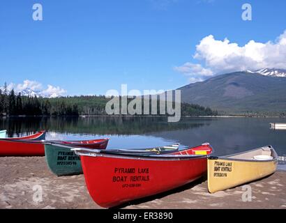 Bunte Kanus am Rande des Pyramid Lake im Frühling, Jasper Nationalpark, Alberta, Kanada. Stockfoto