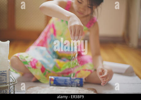 Mädchen sitzen auf dem Boden Backen Stockfoto