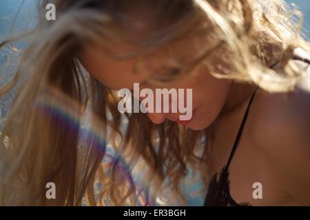 Nahaufnahme einer schönen Frau mit einem Regenbogen aus Licht vor ihrem Gesicht Stockfoto