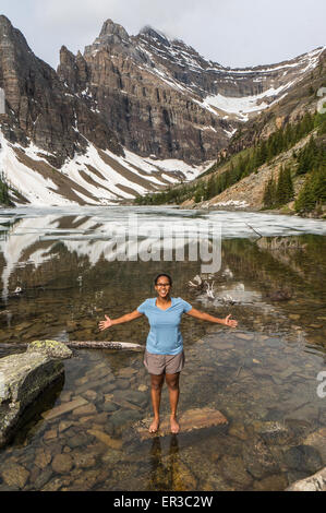 Mädchen steht mit ausgestreckten Armen, Lake Agnes, Banff Nationalpark, Alberta, Kanada Stockfoto