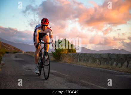 Mann Radfahren bei Sonnenuntergang, Korsika, Frankreich Stockfoto