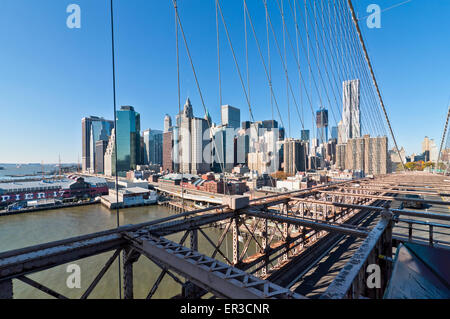 Verkehr auf der Brooklyn Bridge mit der Lower Manhattan Skyline im Hintergrund. Stockfoto