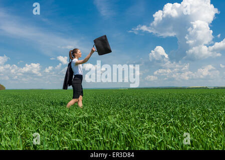 Mädchen mit einer Aktentasche zu Fuß auf dem Rasen Stockfoto