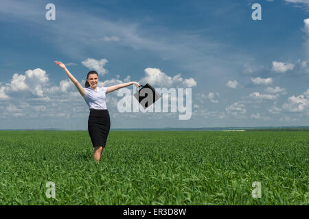 Frau mit einer Aktentasche zu Fuß auf dem Rasen Stockfoto