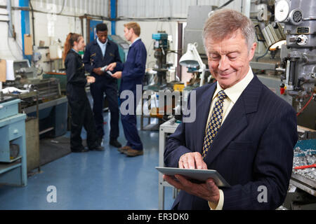 Besitzer des Engineering-Werk mit Digital-Tablette mit Personal im Hintergrund Stockfoto