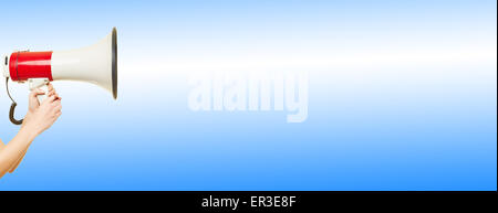 Weibliche Hand hält ein großes Megaphon vor einem blauen Hintergrund Stockfoto