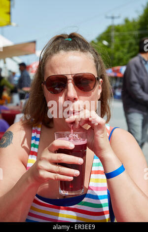 Frau mit Sonnenbrille trinken frisch gepressten Granatapfelsaft in Fethiye, Türkei. Stockfoto