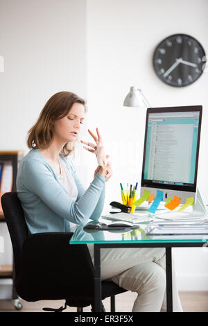 Frau bei der Arbeit leiden, Schmerzen am Handgelenk. Stockfoto