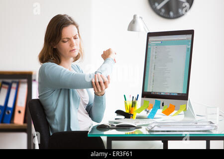 Frau bei der Arbeit leiden unter Schmerzen im Ellbogen. Stockfoto