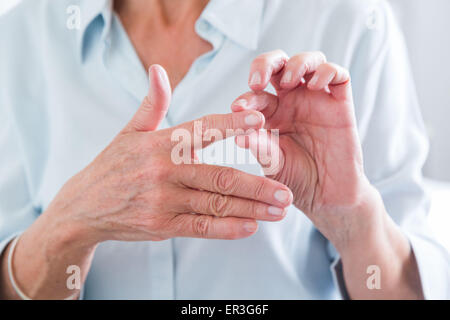 Ältere Frau leidet ein Gelenk Schmerzen in der Hand. Stockfoto