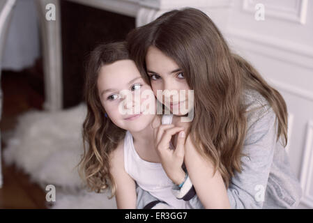 Mädchen umarmen jüngere Schwester, portrait Stockfoto