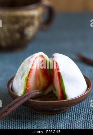 Daifuku mit Erdbeeren und grünem Tee füllen durch eine Tasse Tee Stockfoto