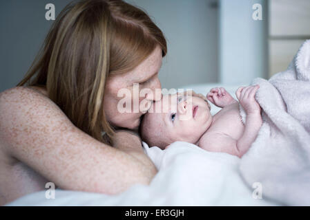 Mutter, neugeborenes Baby küssen Stockfoto