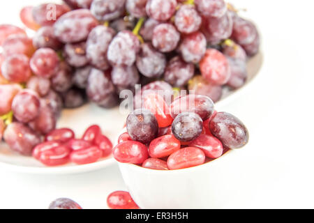 lila Trauben Vs lila Gummibärchen - Entscheidung zwischen gesunde Ernährung oder Junk-Food snack Stockfoto