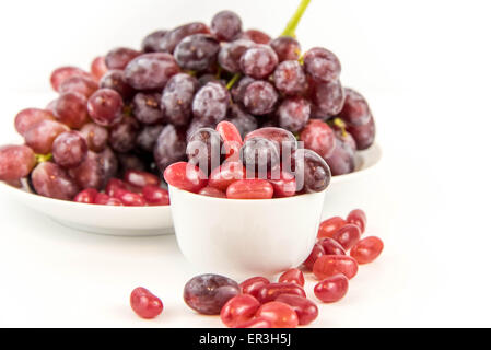 lila Trauben Vs lila Gummibärchen - Entscheidung zwischen gesunde Ernährung oder Junk-Food snack Stockfoto