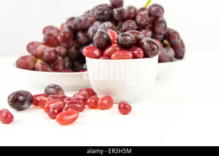 lila Trauben Vs lila Gummibärchen - Entscheidung zwischen gesunde Ernährung oder Junk-Food snack Stockfoto