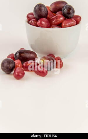 lila Trauben Vs lila Gummibärchen - Entscheidung zwischen gesunde Ernährung oder Junk-Food snack Stockfoto