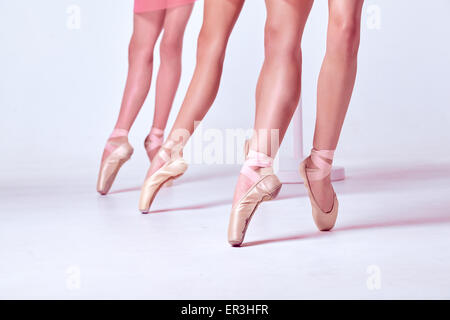 Die Füße der jungen Ballerina in Spitzenschuhen Stockfoto