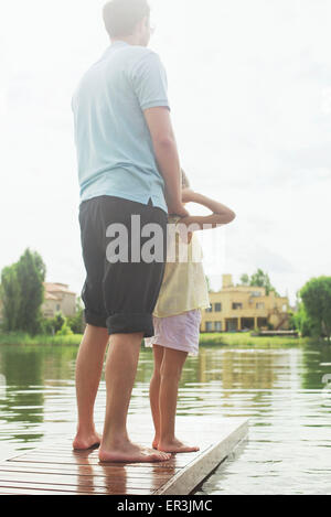 Vater und Tochter stehen zusammen am Ende See Pier betrachten Stockfoto