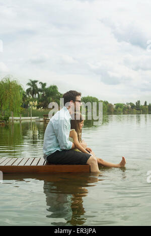 Vater und Tochter sitzen auf dock genießen Landschaft Stockfoto