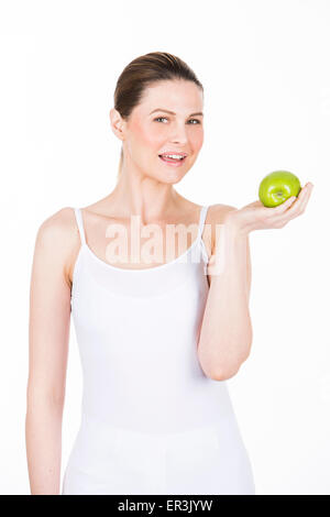 junge Frau hält einen Apfel und Blick in die Kamera Stockfoto