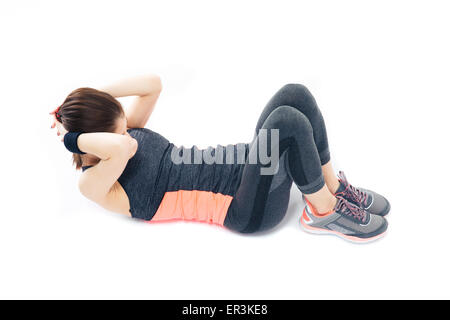 Sportliche junge Frau tut Bauch Übungen Isolatedon einen weißen Hintergrund Stockfoto