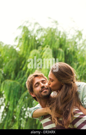 Junge Frau küssen Freund Stockfoto